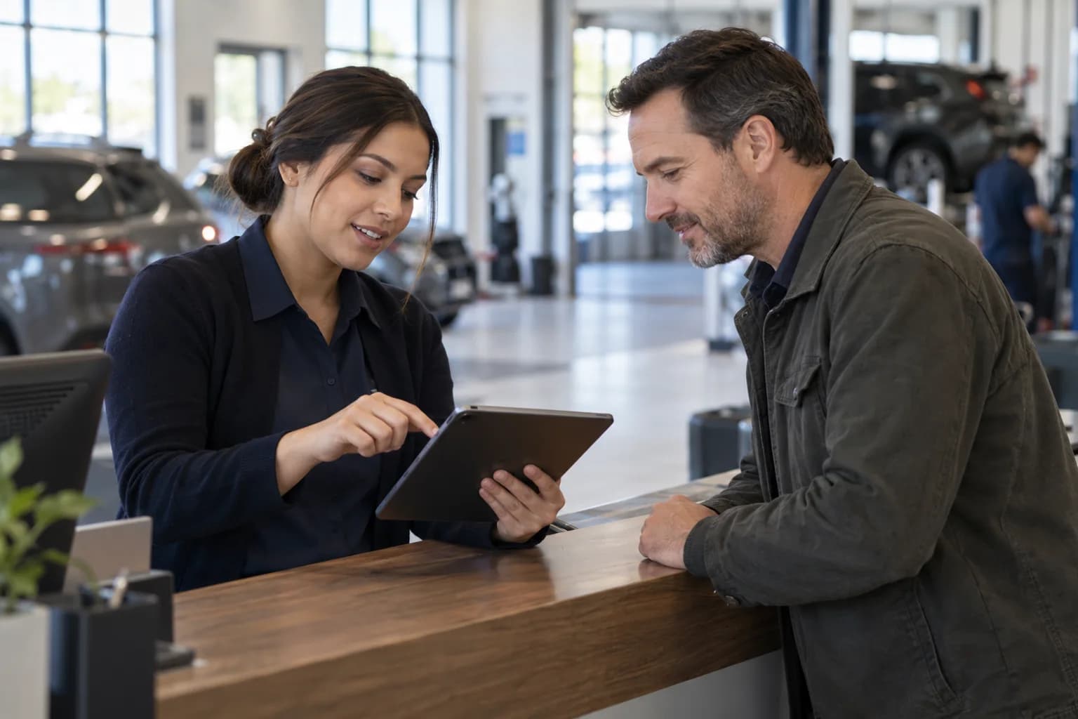 Automotive service coordinator reviewing an appointment with a customer