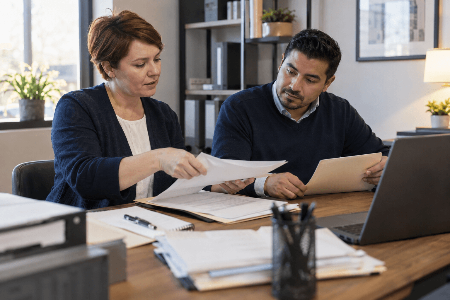 Administrative colleagues organizing customer records and paperwork